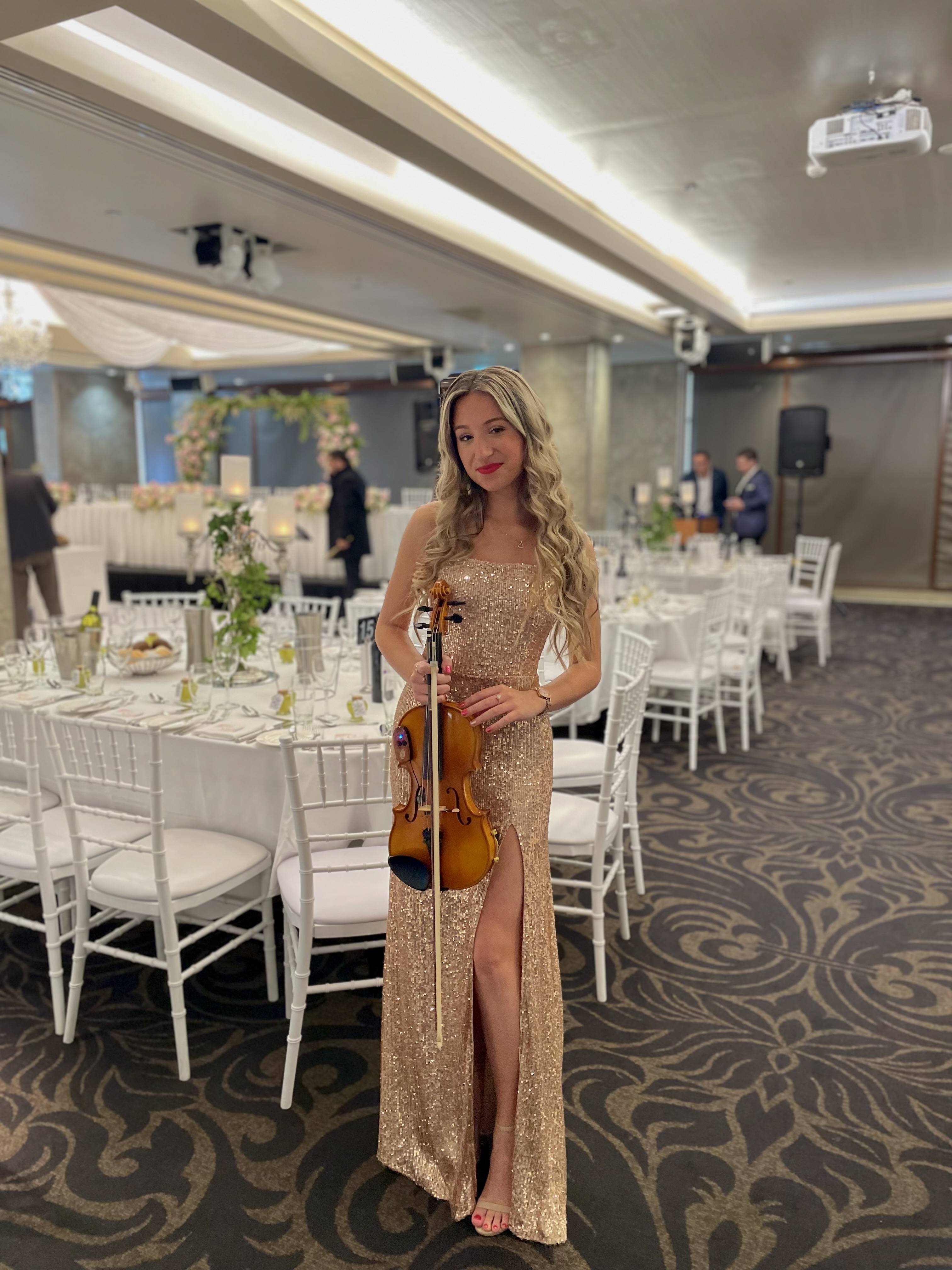 Tali in beige dress at dinner wedding performance